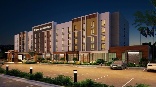 A modern hotel with a prominent sign, multiple floors, and a well-lit entrance. - Hilton Garden Inn Elizabethtown, KY (Elizabethtown)