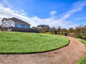 Stroll along the curved path to this charming home, surrounded by a well-manicured lawn and a wooden fence.
