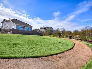 Stroll along the curved path to this charming home, surrounded by a well-manicured lawn and a wooden fence.