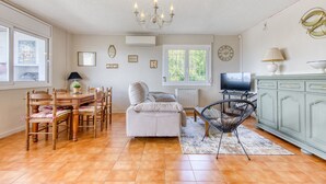 A cozy living room with a dining table, chairs, a sofa, a TV, and a cabinet. - RUBENS C1 Almadrava (Rosas / Roses)