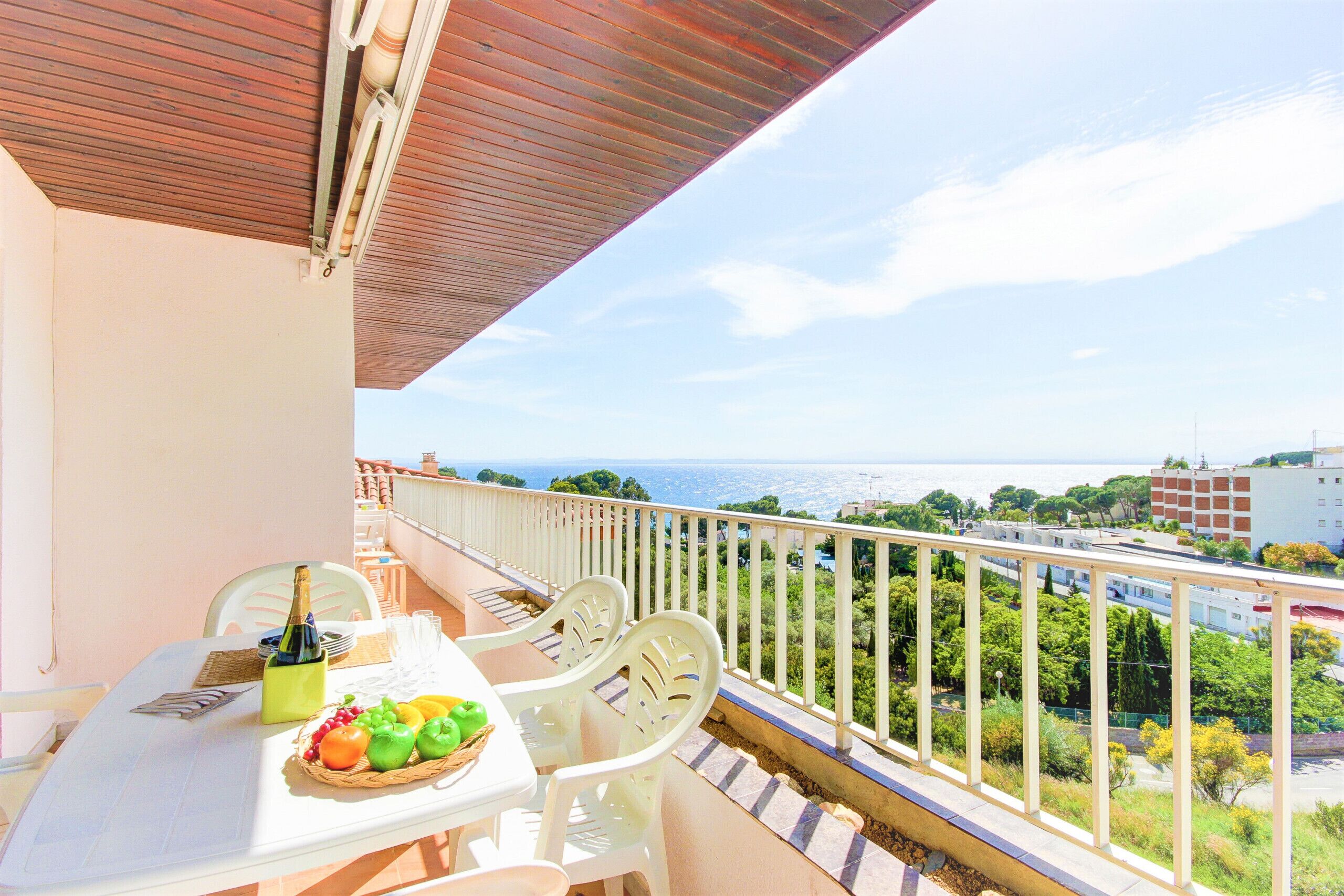 Ein Balkon mit Tisch für zwei Personen, einer Champagnerflasche und einer Obstauswahl.
