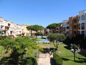 Un immeuble résidentiel doté de nombreux balcons, d’une piscine et d’une pelouse bien entretenue.