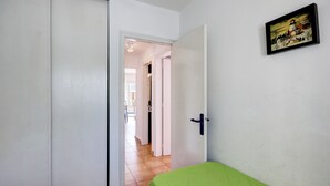Una habitación con una cama, una puerta y un cuadro en la pared.