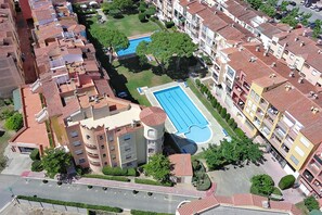 Vue aérienne d’un quartier résidentiel avec une piscine entourée d’immeubles d’appartements.