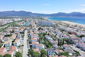 Una zona residencial costera con un puerto deportivo, un hotel grande de diseño arquitectónico distintivo y una playa.