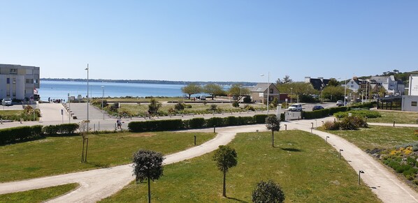 A coastal view with a clear sky, a pathway, and a body of water.