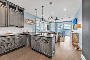 Enjoy a spacious living area with a view of the outdoors from the balcony, complemented by a modern kitchen with ample storage and a large island.