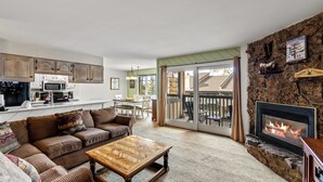 A cozy living room with a fireplace, a dining area, and a kitchen. - Cozy 2-Bedroom Ground-Floor Condo at The Phoenix – Steps from the Slopes! (Steamboat Springs)