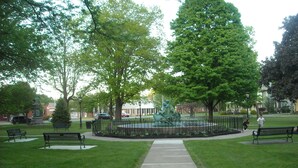 A park with benches, a statue, and a pathway.