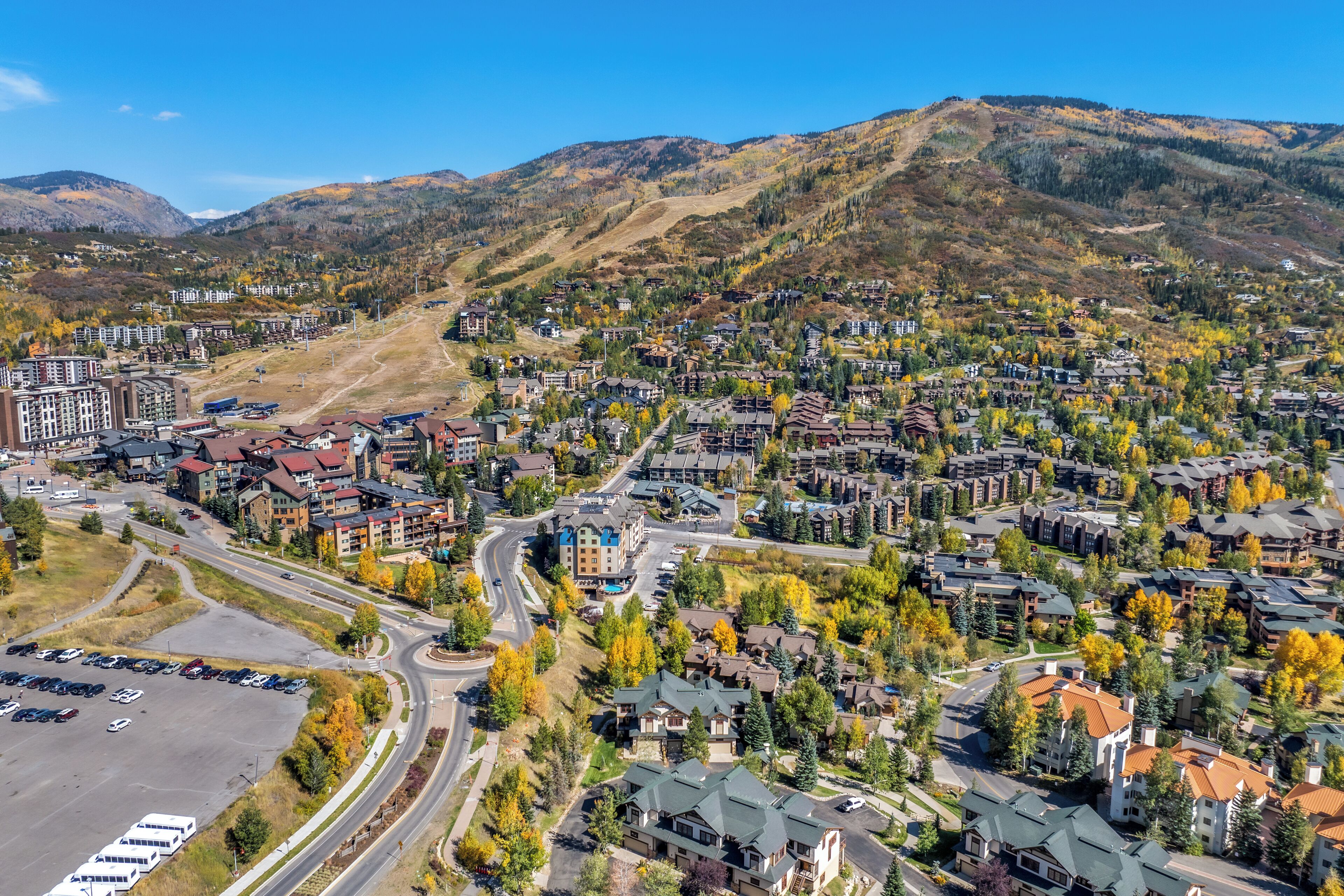 A residential area with a mix of single-family homes and apartment buildings, roads, and a parking lot.