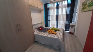 A small bedroom with a bed, a wardrobe, a heater, and a window with curtains. - Casa a Medida (Las Palmas de Gran Canaria)