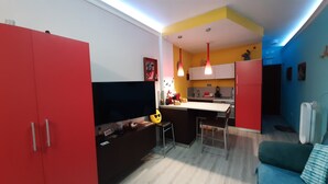A modern kitchen with a dining area, a TV, and a sofa. - Casa a Medida (Las Palmas de Gran Canaria)