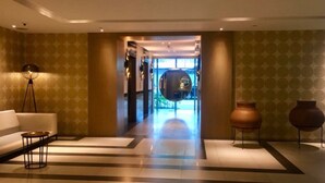 Eine moderne Lobby mit einer Couch, einer Stehlampe und zwei Vasen.