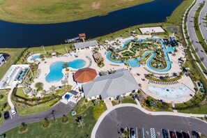An aerial view of a resort with multiple swimming pools, a large building, and a road nearby. - 7BR Pool Home Emerald Island by SHV-8409 (Kissimmee)