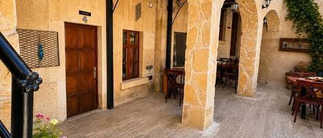 A stone building with a wooden ceiling and multiple doors, including a visible entrance.