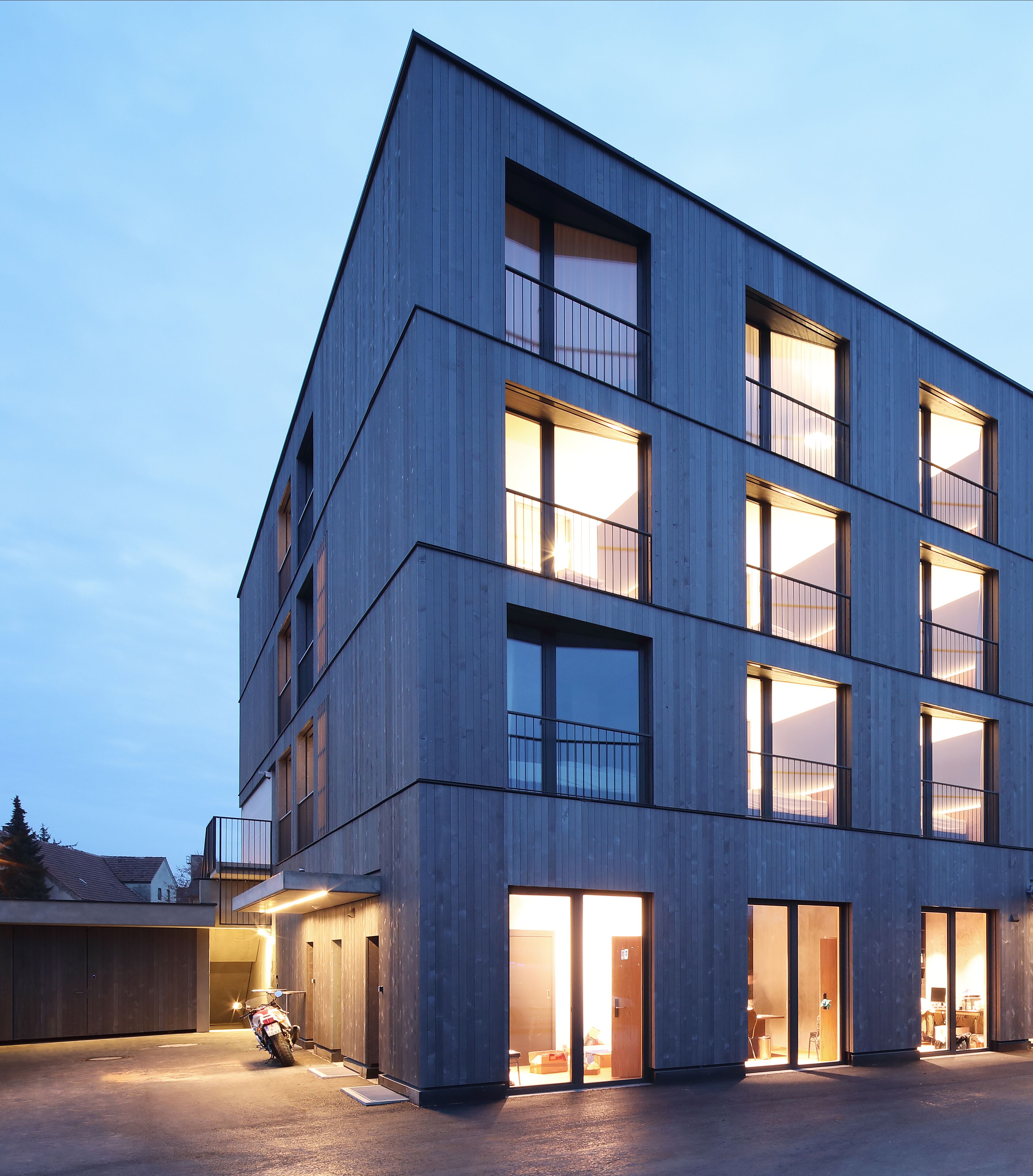 Un edificio moderno de varios pisos con amplios ventanales y techo plano.