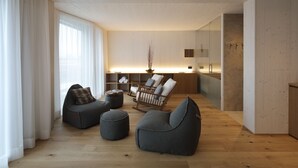 Una sala moderna con piso de madera, dos sillones de peluche, un sillón mecedora y una mesita auxiliar.