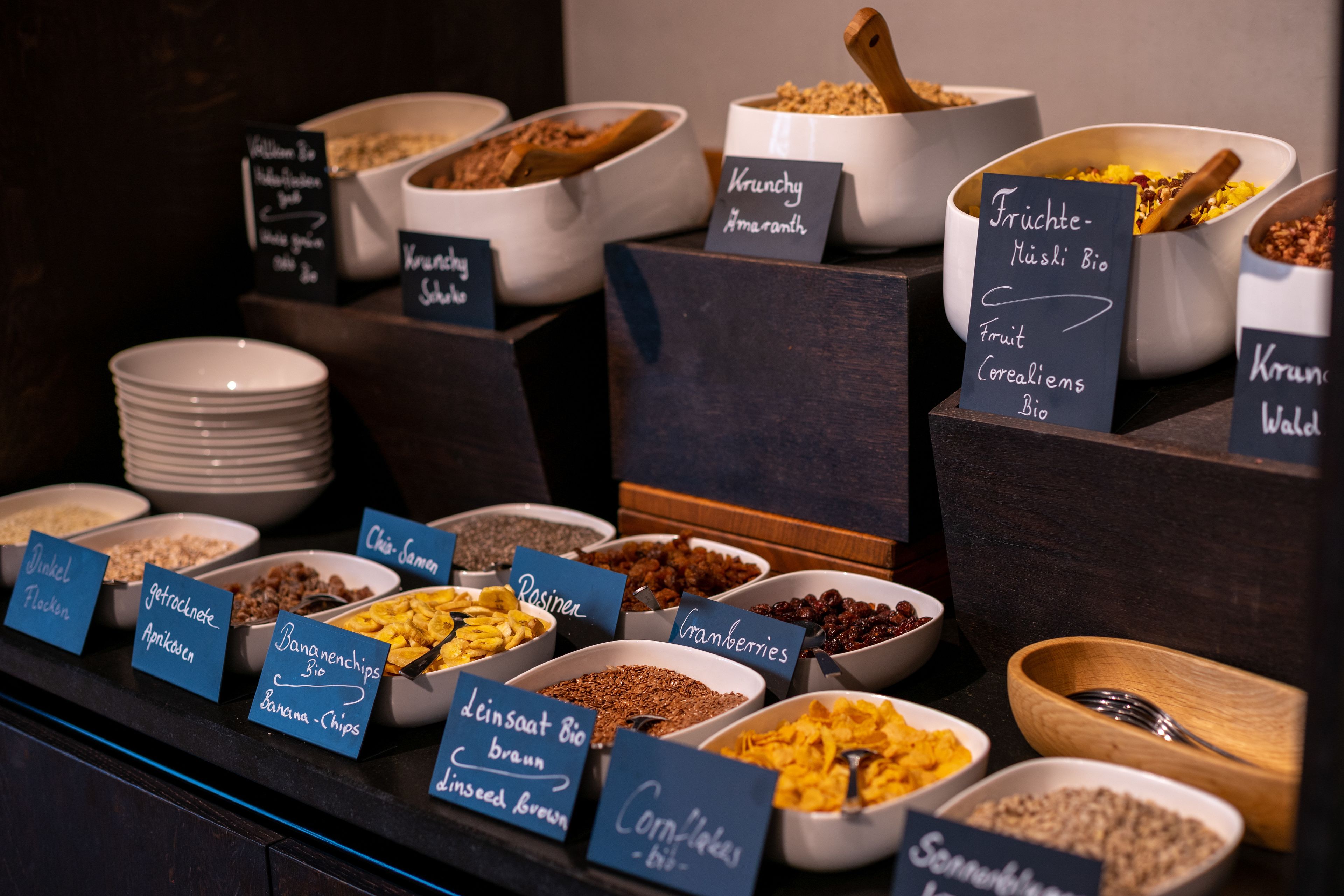 Ein Buffet mit verschiedenen Speisen, beschriftet in mehreren Sprachen.