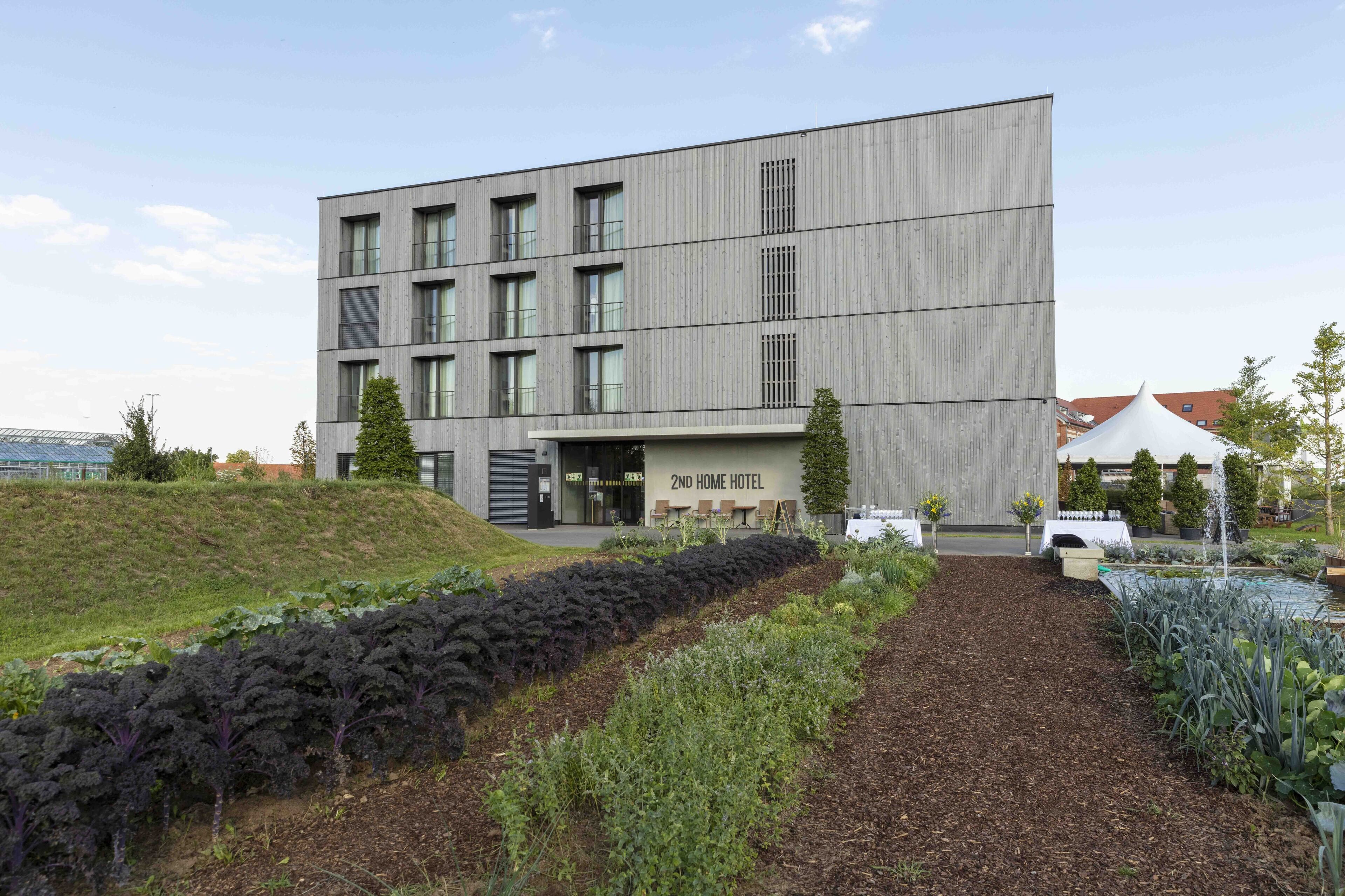 Un edificio moderno con un cartello che riporta la scritta "2nd Home Hotel".