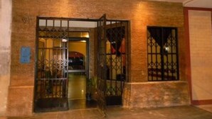 A building entrance with a metal gate and a small step leading up to the door. - Amazon Dream Hostel (Iquitos)