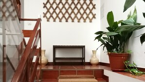 A staircase with a wooden handrail, a woven carpet, and a lattice wall decoration. - Casa da Travessa (Ponte de Lima)