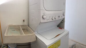 A laundry area with a washing machine and a large basin. - Olivos Apart (Playa del Carmen)