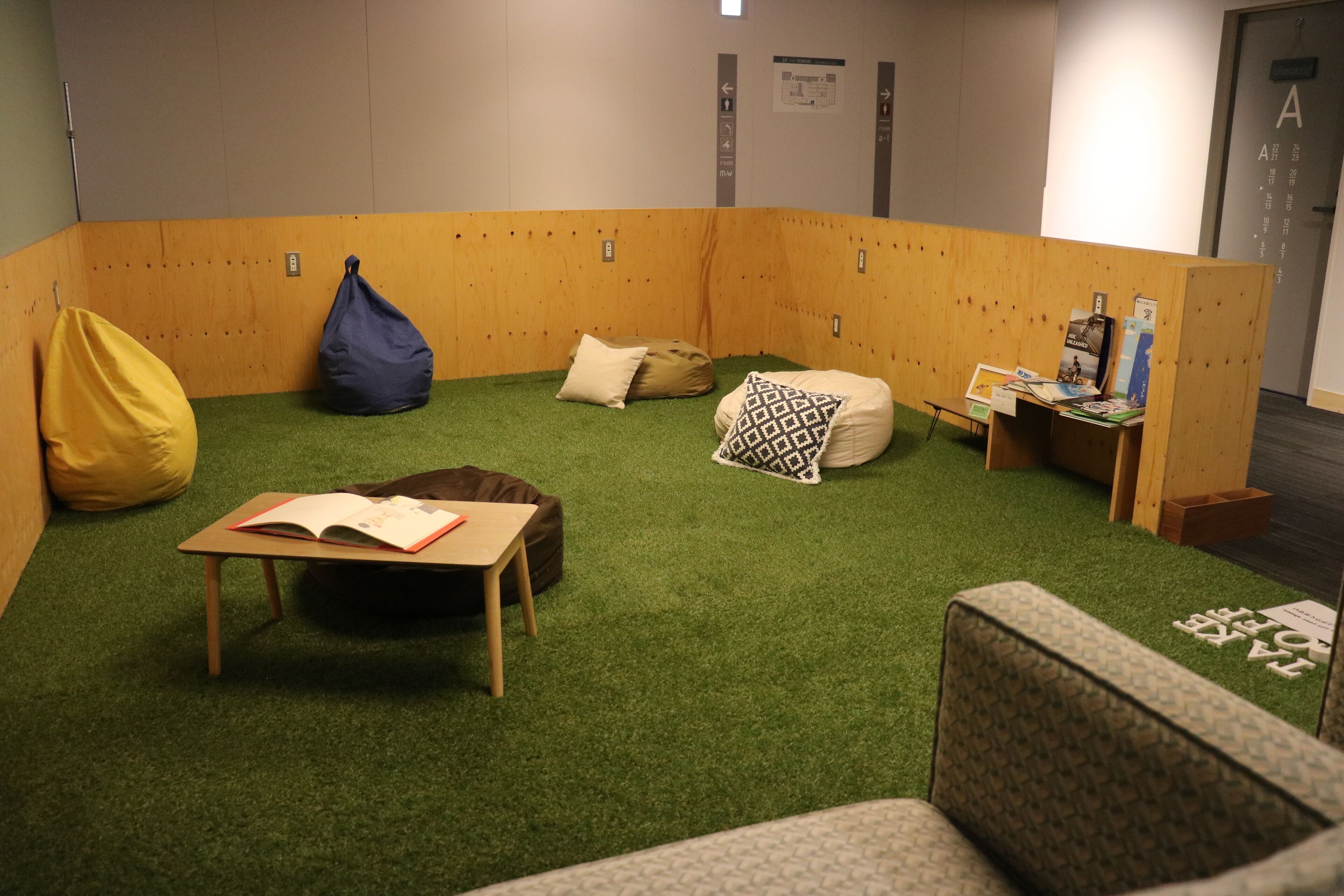 A cozy reading nook with a small table, bean bag chairs, and a bookshelf.
