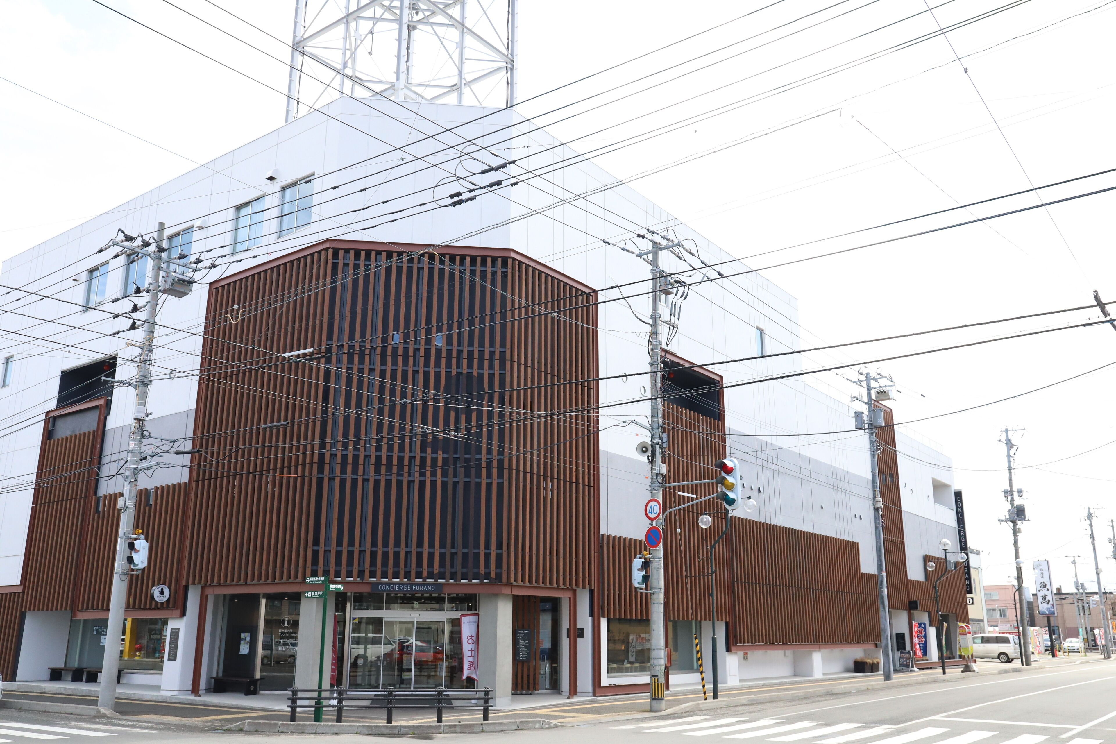 A modern building with a prominent corner design, multiple floors, and visible signage for a restaurant.