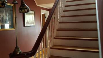 A staircase with white balusters and wooden steps, leading to an upper floor.