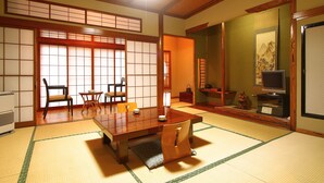 A traditional Japanese room with tatami flooring, a low wooden table, and sliding doors. - Mogamiya Ryokan (Shiroishi)