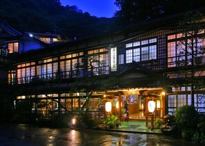 Edificio japonés tradicional con múltiples ventanas y un cartel que indica un restaurante.