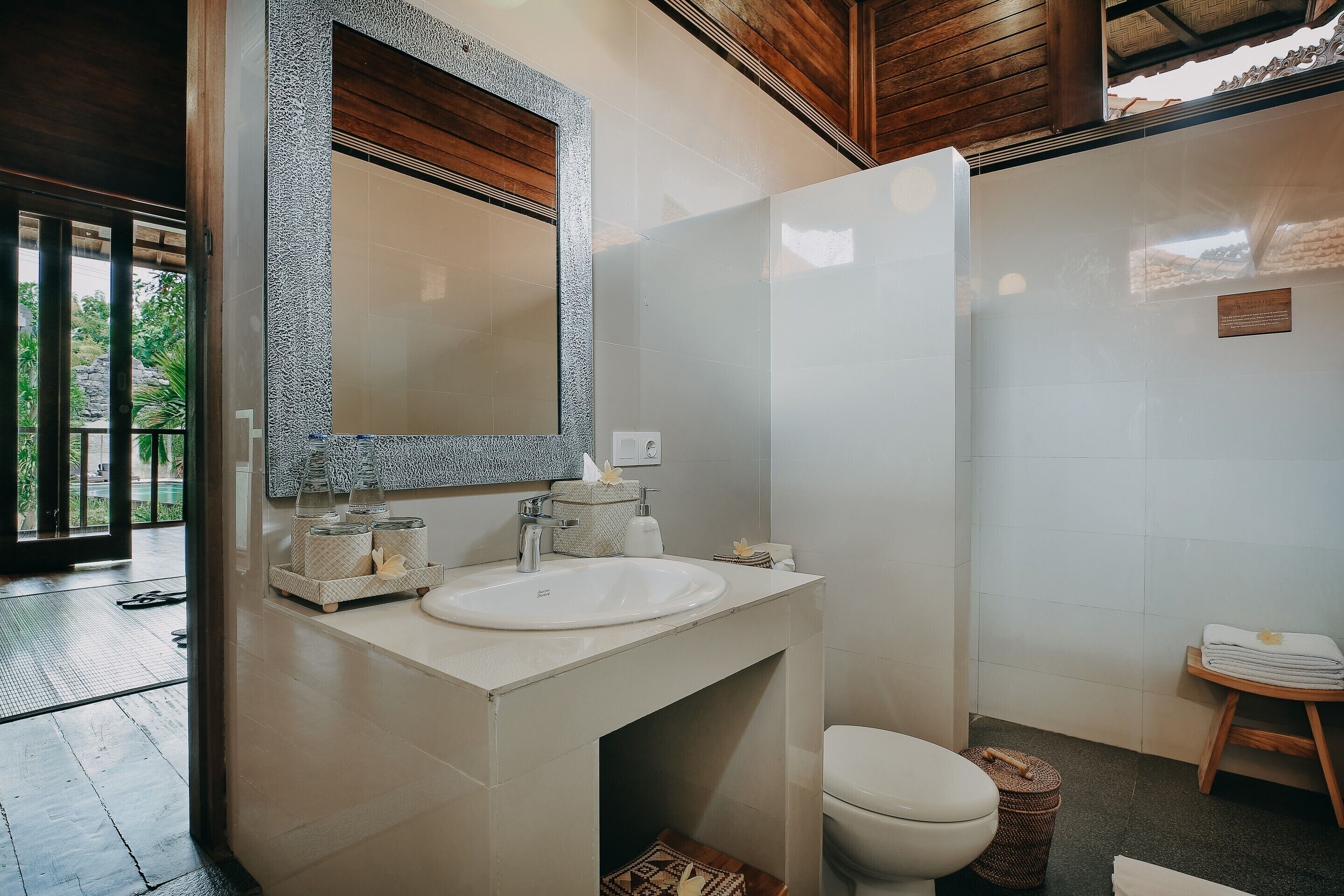 Een badkamer met een witte wastafel, een spiegel en een toilet.