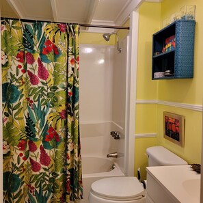 Ein Badezimmer mit Dusche, Toilette und Ablagefläche für Dekoration.