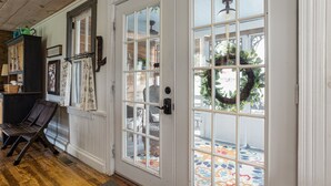 A room with a wooden floor, a bench, a cabinet, and a door with a wreath. - Historical Property, Mountain View’s quiet country life. (Stanley)