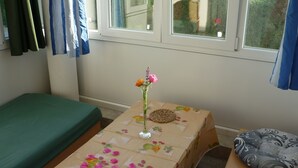 A small room with a single bed, a table with a floral tablecloth, and a window with curtains. - Apartment Studio A2_Croatia, Istria, Medulin (Medulin)