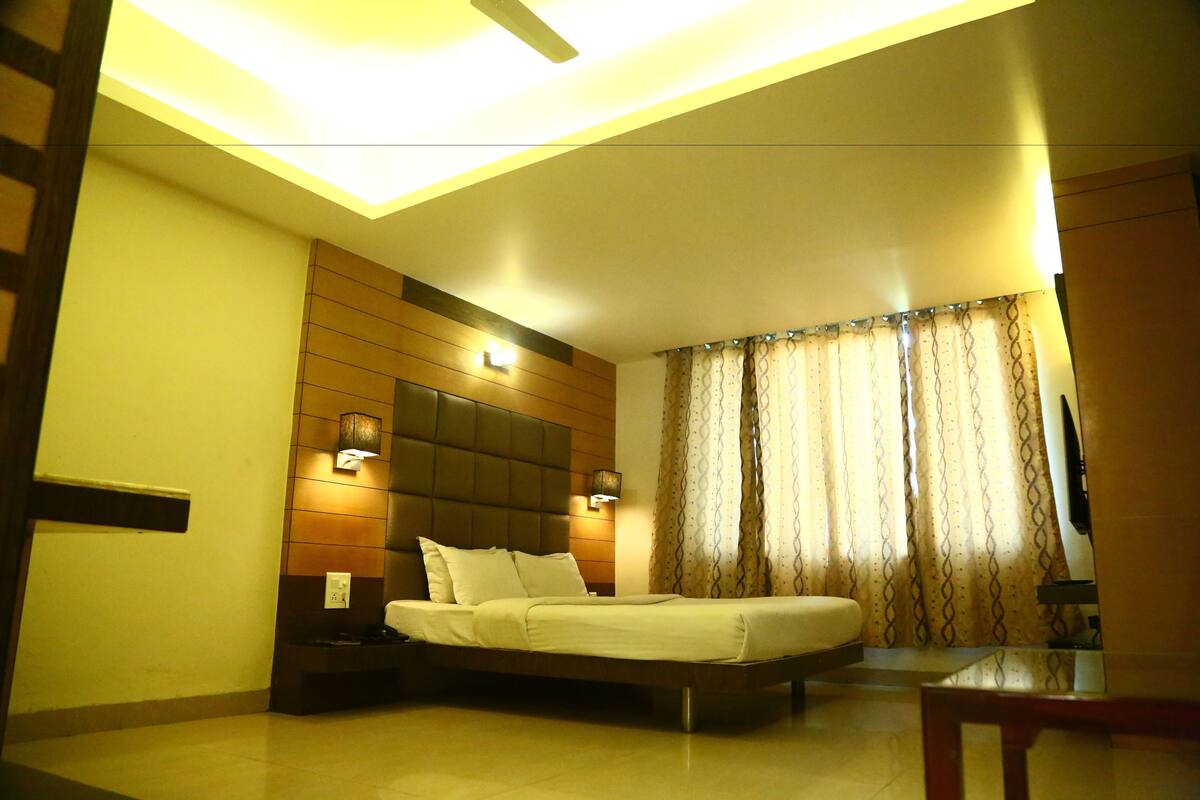 Une chambre à coucher moderne, avec un lit, des tables de chevet et un luminaire au plafond.
