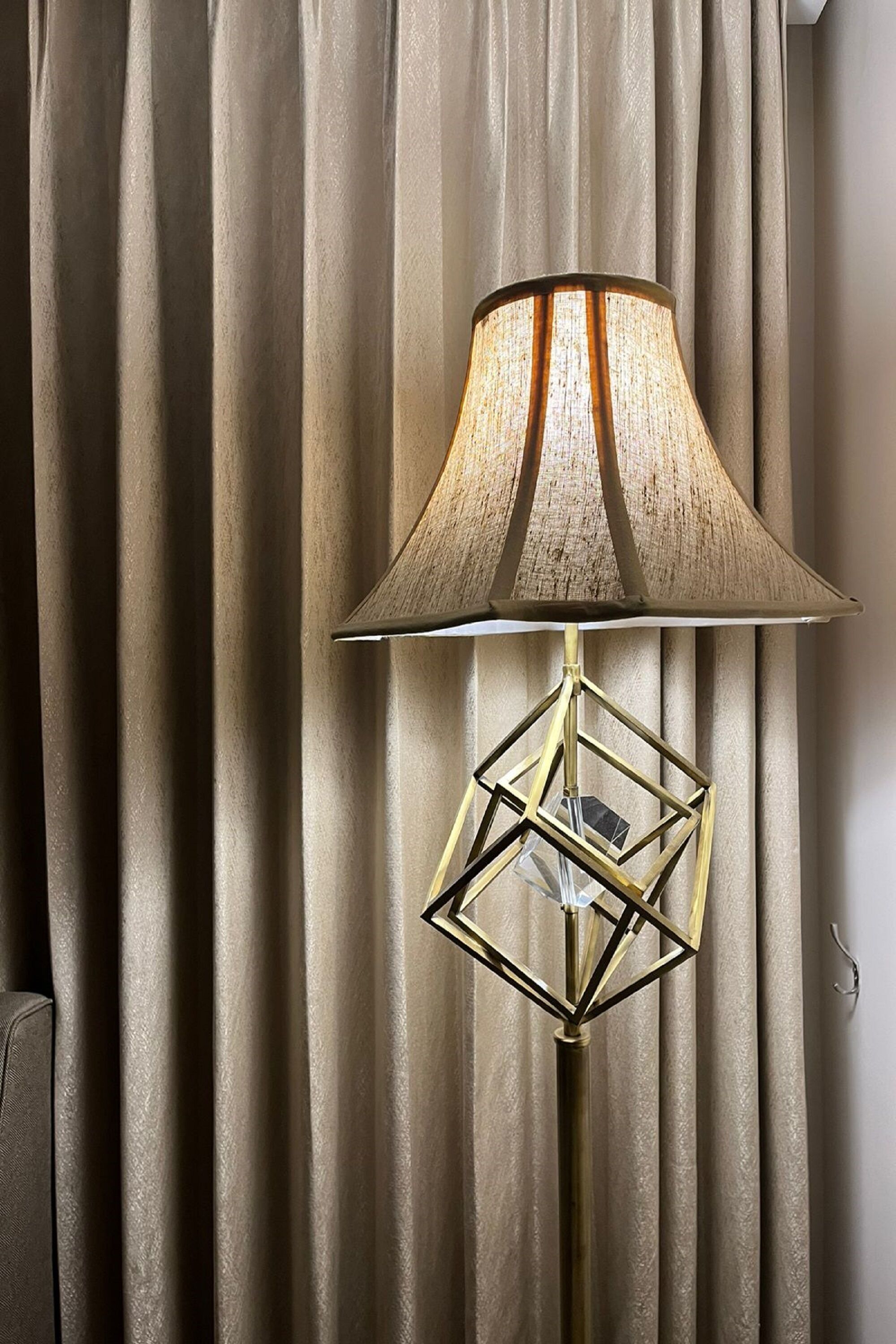 A floor lamp with a geometric base and a textured lampshade.