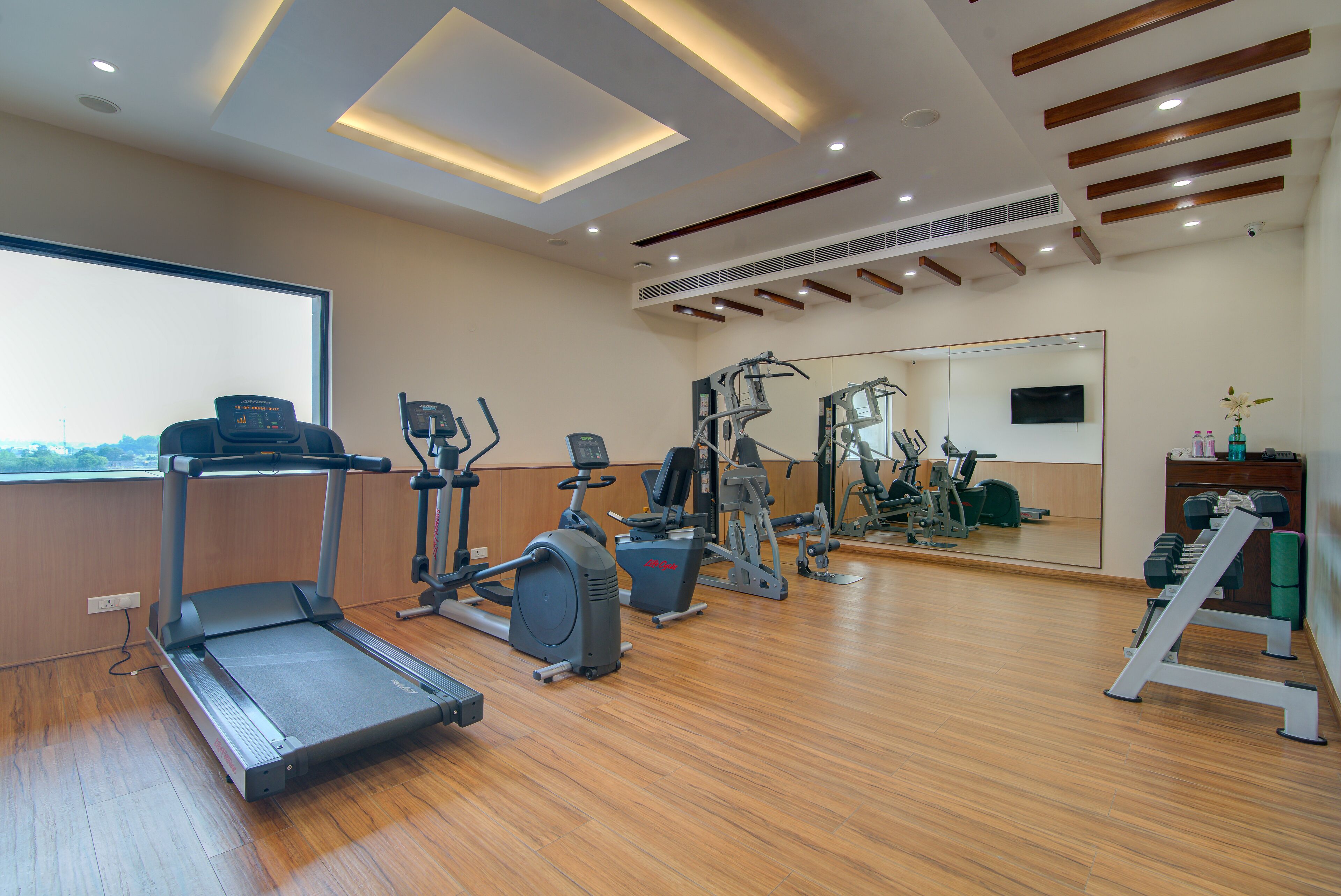 A gym with treadmills, elliptical machines, and weight equipment.