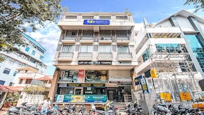 A multi-story building with a sign for 'Fab Hotels' on the top. - FabHotel Oriental Suites MG Road (Bengaluru)
