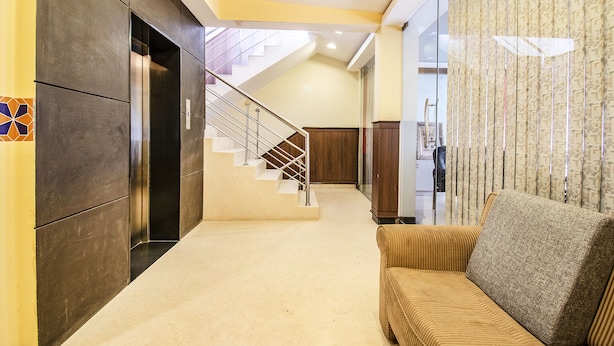 A modern interior with a staircase, a sofa, and a patterned curtain. - FabHotel Oriental Suites MG Road (Bengaluru)