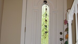 Una puerta blanca con un vitral que muestra un diseño de jinete y caballo.