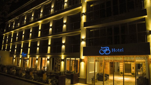 A hotel with a modern facade, multiple balconies, and a well-lit entrance. - B Hotel Bishkek (Bishkek)