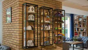 A brick wall with a glass display case containing various decorative items. There is a sofa and a table in the room. - B Hotel Bishkek (Bishkek)
