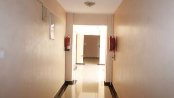 A hallway with a fire extinguisher, a sign reading "WING A", and a door at the end.