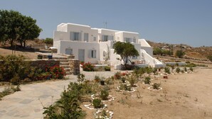 Un edificio blanco con múltiples ventanas y una escalera de piedra que conduce a la entrada.