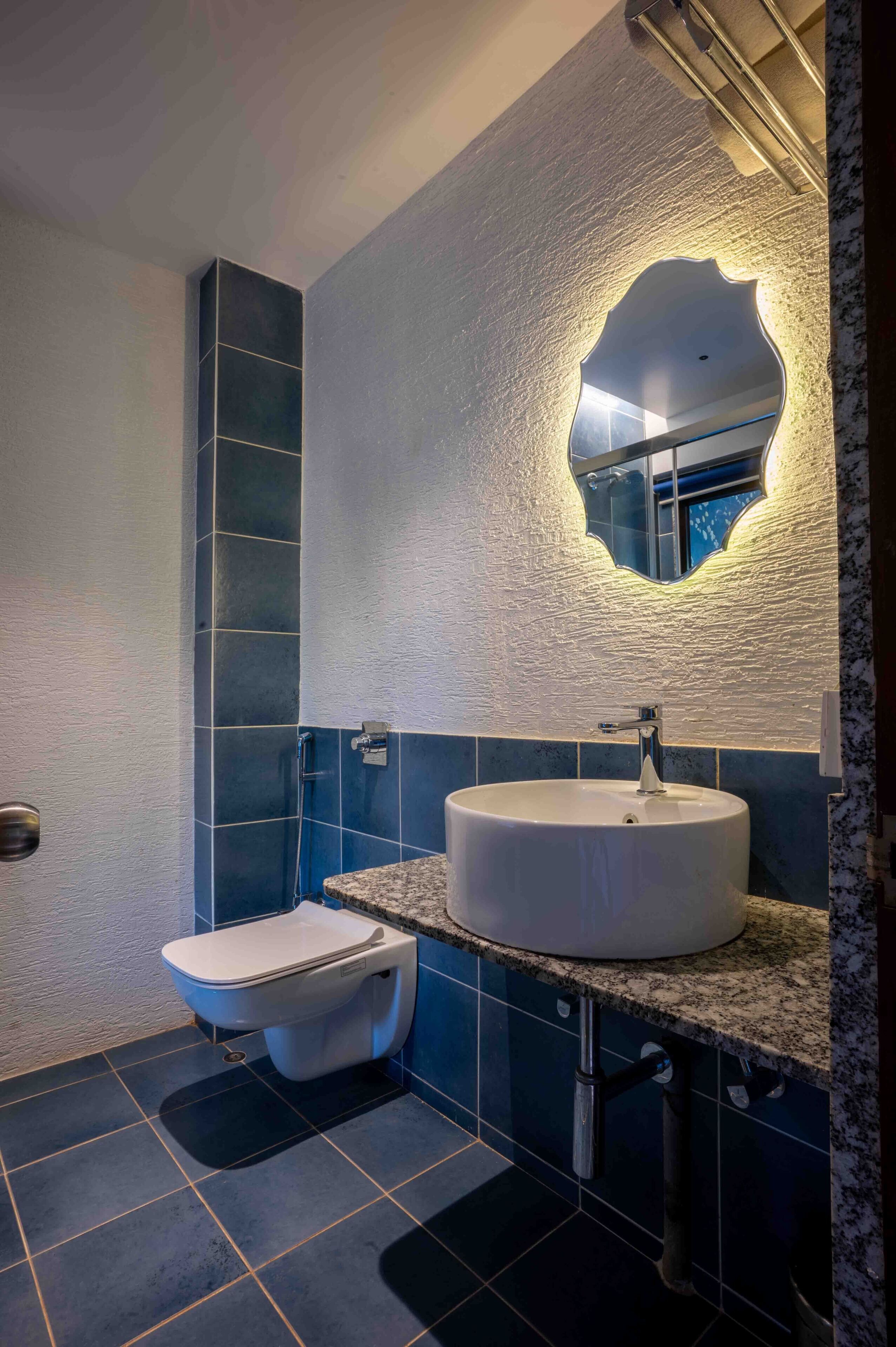 A bathroom with a white sink, a mirror, and a toilet.