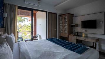 Camera d'albergo con un letto grande, televisione, scrivania e balcone con vista sulle palme.