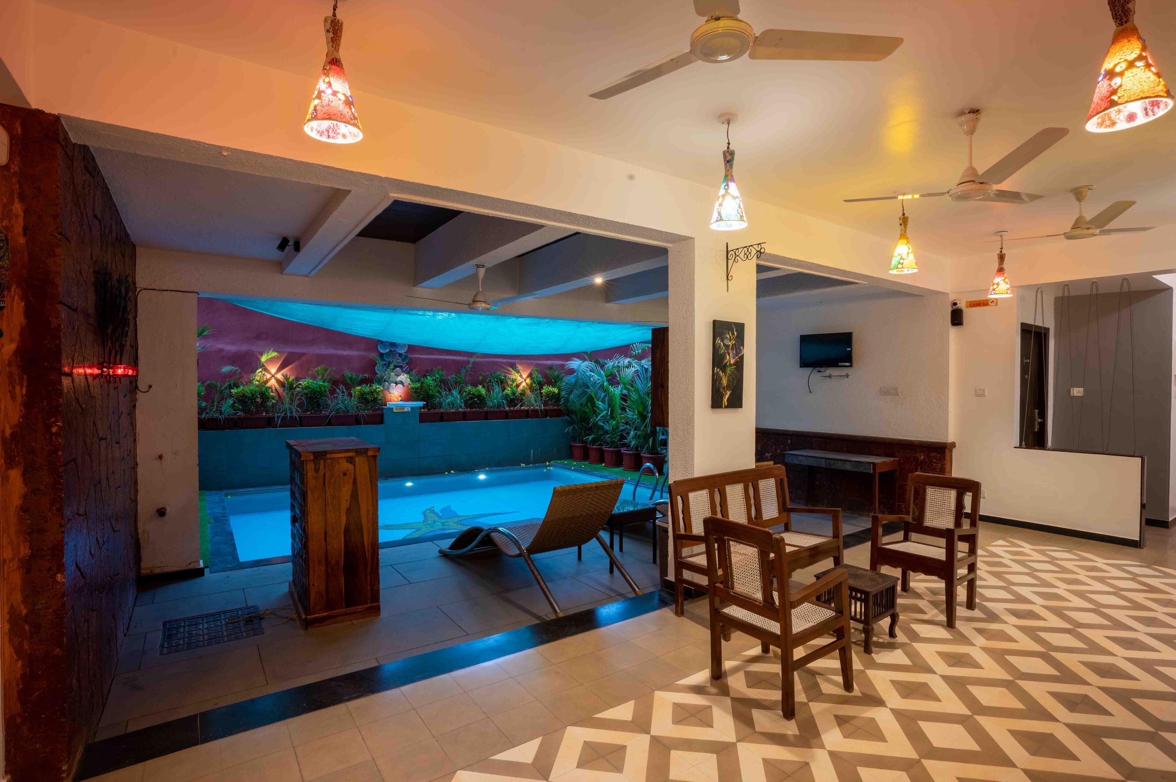 A spacious room with a pool, ceiling fans, and a patterned floor.