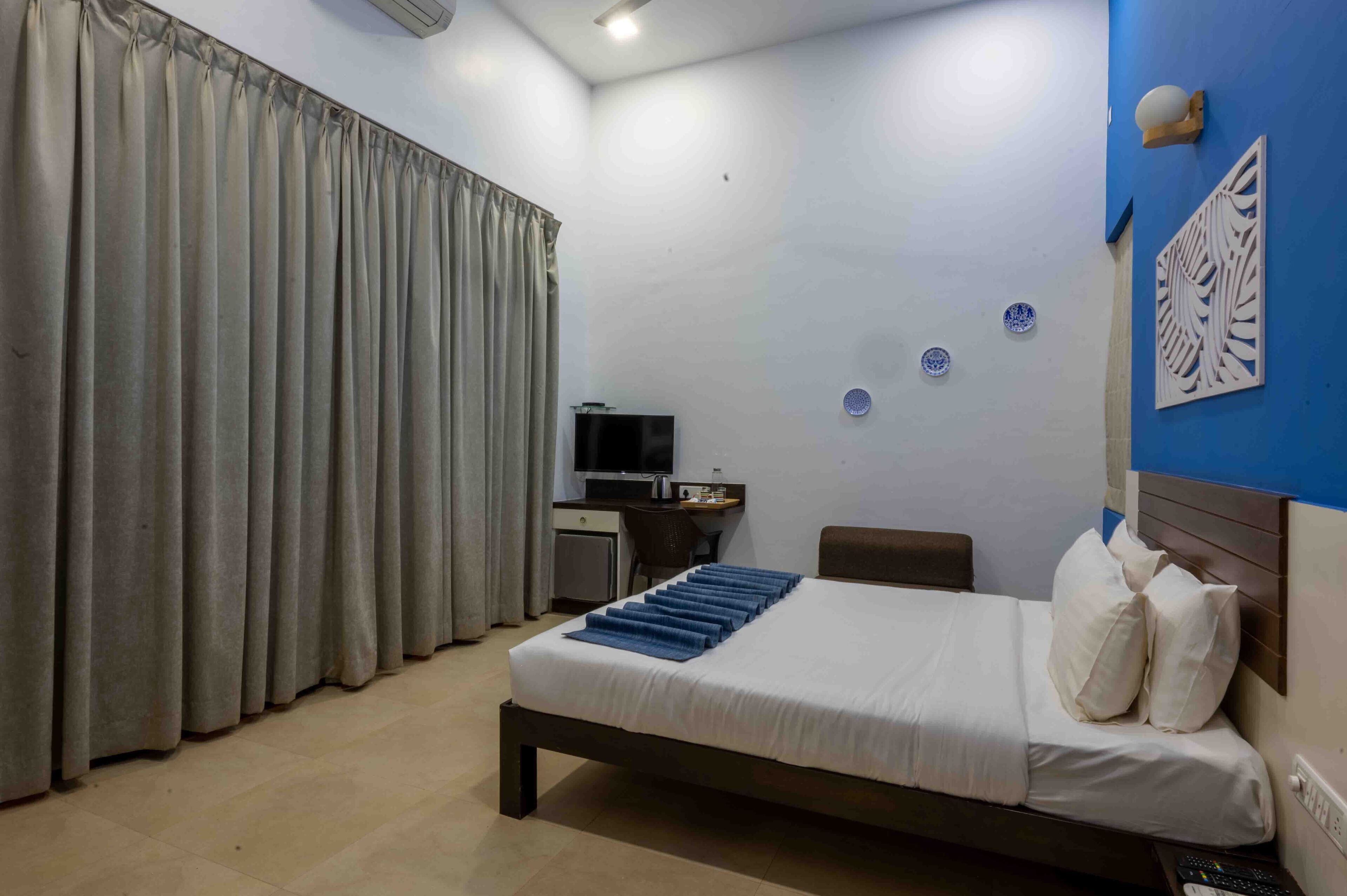 Une chambre d’hôtel équipée d’un lit, d’un bureau, d’une chaise et d’un téléviseur.