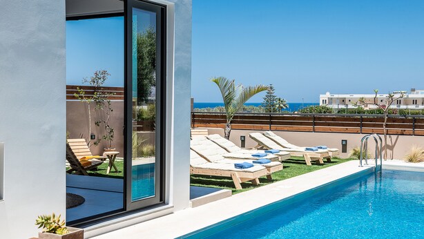 A modern pool area with lounge chairs and a clear view of the sea. - Fos Villa your place under the Cretan Sun with private heated pool (Chania)